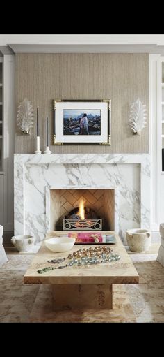 a living room filled with furniture and a fire place in the middle of a fireplace