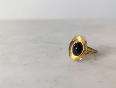 A stunning gold tone ring with large black stone, with aged patina on the band, that would make the perfect jewellery gift for you or a special someone. Colour: Gold, Black Materials: Metal Ring Size:  Size: D2cm  approx Info: In good vintage condition Check out our Instagram page, give us a follow and a ❤️, https://www.instagram.com/curiofoundation/ All net profits from this sale go directly to the Curio Foundation, your support helps us do vital work, so lives can be supported and changed. If you have any questions do not hesitate to ask. If you need next day delivery I can get a quote to you. Black Brass Rings For Gift, Vintage Gold Rings With Black Enamel, Christmas Deals, Jewellery Gift, Instagram Page, Metal Ring, Black Stone, Metal Rings, Rings Statement