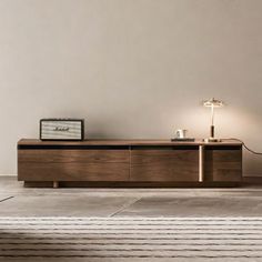 a living room with an entertainment center and lamp on the side table in front of it