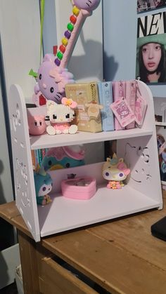 a shelf with hello kitty toys on top of it and other items in the background