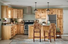 a kitchen filled with wooden cabinets and chairs next to an open refrigerator freezer oven