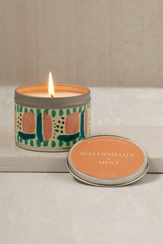 a candle that is sitting next to a tin with watermelon mint on it