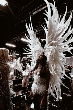 two women dressed in feathery clothing standing next to each other