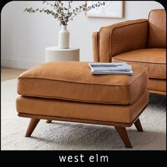 a chair and ottoman in a living room with the words west elm written on it