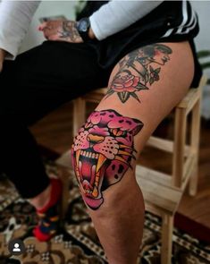 a person sitting on a chair with a tiger tattoo on their arm and leg,