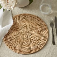 a place setting with flowers, silverware and napkins on a linen tablecloth