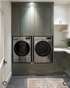 a large washer and dryer in a small room with cabinets on either side