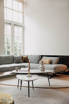 a living room with a couch, coffee table and large window in it's center