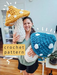 a woman holding two crocheted mushrooms in her hands