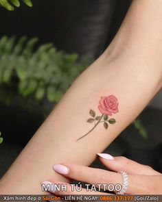 a woman's arm with a small rose tattoo on the left side of her arm