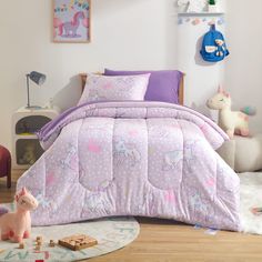 a child's bedroom with pink and purple bedding, toy animals and toys on the floor