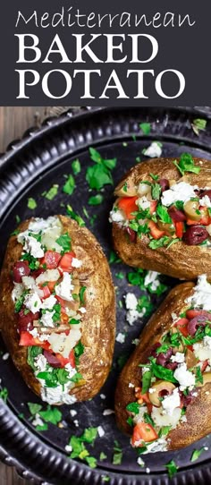 three baked potatoes on a black plate topped with feta cheese and chopped green herbs