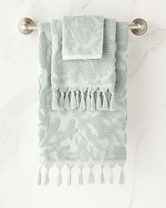 a white towel hanging on the wall with tassels and fringed trim around it