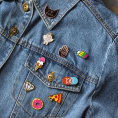 a denim jacket with several pins on it