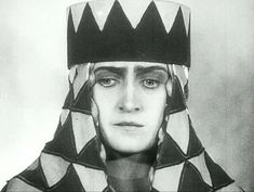 an old photo of a woman wearing a hat with black and white designs on it