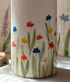 three vases with colorful flowers painted on them