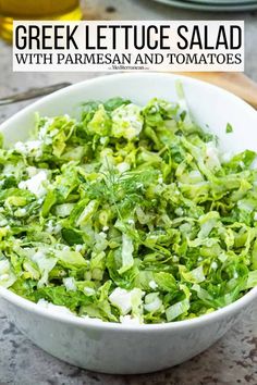 greek lettuce salad with parmesan and tomatoes in a white bowl