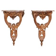 a pair of wooden brackets with carvings on them