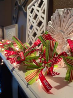 christmas lights and ribbons are on the counter in front of a vase with a flower