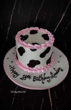 a birthday cake decorated with black and white polka dots