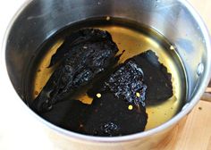 two pieces of black meat are in a saucepan