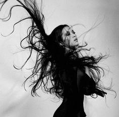 a woman with her hair flying in the air