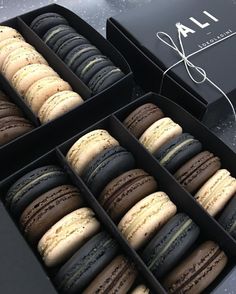 an open box of macaroons sitting on top of a table next to each other