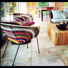 a living room filled with lots of furniture and decor on top of stone flooring