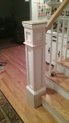 a stair case in the middle of a hardwood floored area with white stairs and handrails