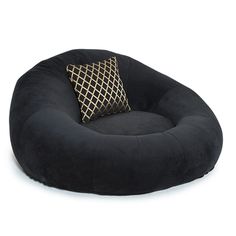 a black round dog bed with a gold accent pillow on it's front and side