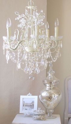 a crystal chandelier sitting on top of a table next to a white chair