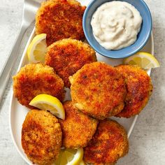 crab cakes with lemon wedges and tartar sauce