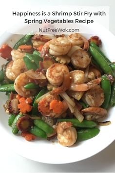 a white plate topped with green beans and shrimp