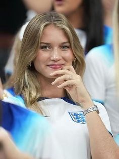 a beautiful young blonde woman sitting in the stands