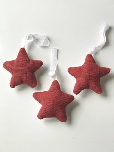 three red stars hanging from white ribbon