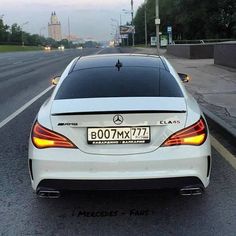 the back end of a white mercedes cla parked on the side of the road