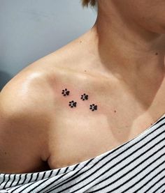 a woman's chest with three small paw prints on her left shoulder and the word dog written in black ink