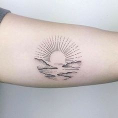 a person's arm with a tattoo on it that has the sun and clouds