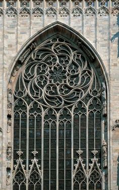 an ornate iron window on the side of a building