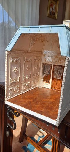 an open doll house sitting on top of a wooden table