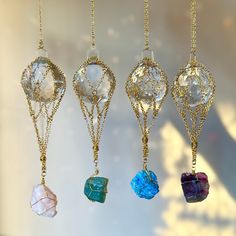 four different colored stones hanging from gold chains