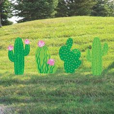 three cactus cut outs sitting in the grass