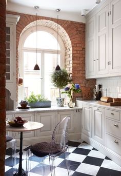 a kitchen with white cabinets and black and white checkered flooring on the floor