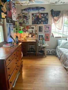 a bedroom with wooden floors and lots of pictures on the wall