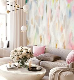 a living room filled with furniture and a large painting on the wall above it's coffee table