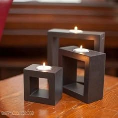 three square candles are sitting on a table