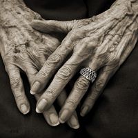 an old woman's hands with wrinkles on her fingers and ring in the middle