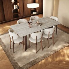 a dining room table with chairs and a rug on the floor in front of it