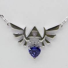 a necklace with a heart shaped blue stone in the shape of an arrow and wings