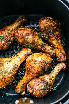 chicken wings cooking in a skillet with herbs